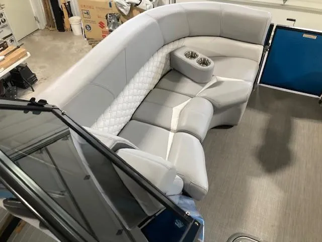 Slide: The Image of 2019 Manitou 25 Legacy LT RFXW boat interior with plush seating and cup holders. - 4