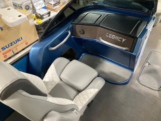 Slide: The Image of 2019 Manitou 25 Legacy LT RFXW boat interior with gray seating and dashboard. - 6