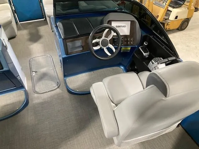 Slide: The Image of 2019 Manitou 25 Legacy LT RFXW boat interior with steering wheel and control panel. - 7