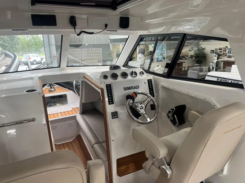 Slide: The Image of Interior of 2025 Protector 310 Targa boat with modern controls and seating. - 10