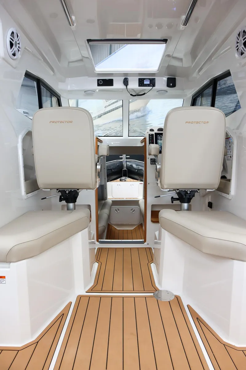 Slide: The Image of Interior of 2025 Protector 310 Targa boat with modern seating and wood flooring. - 11
