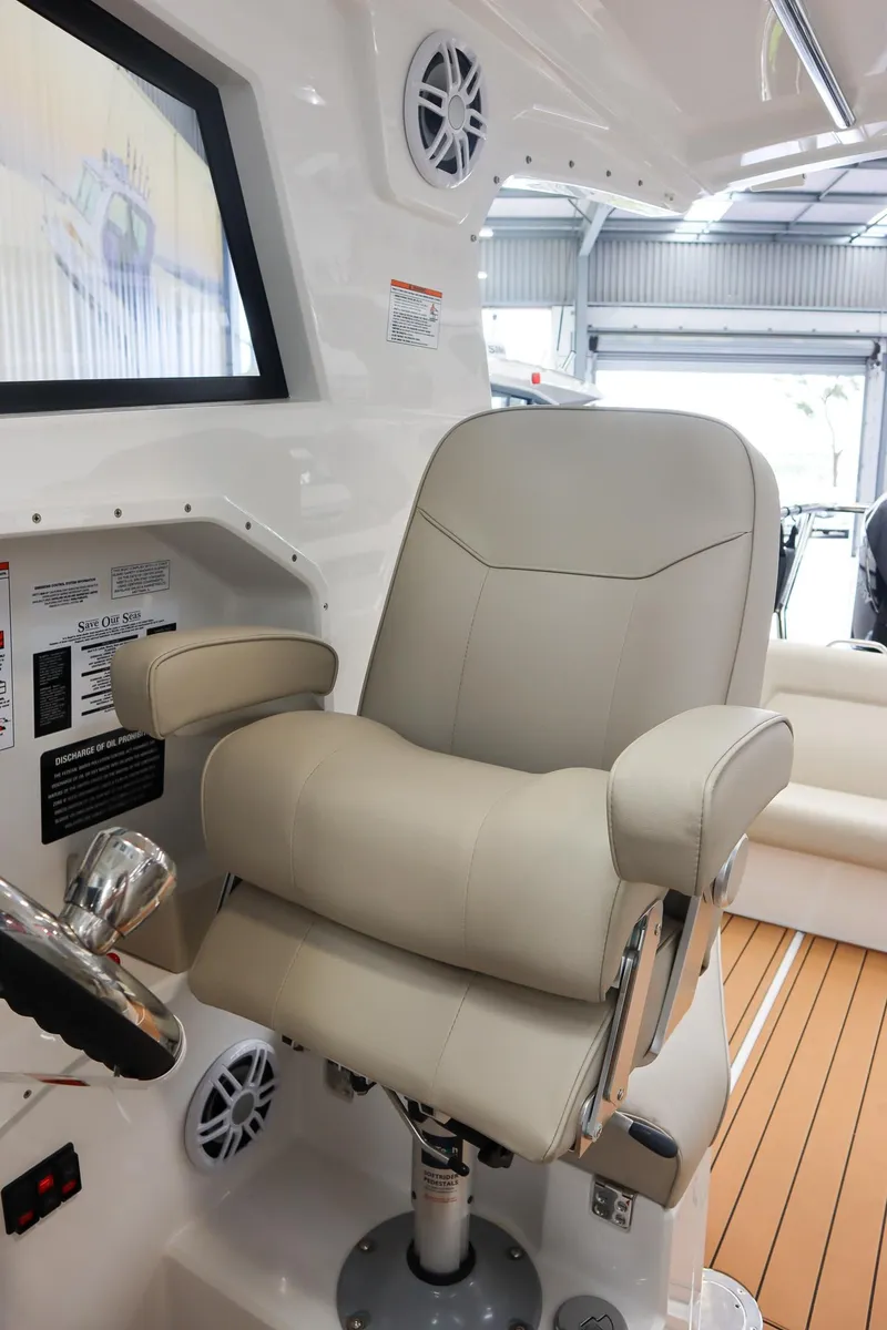 Slide: The Image of Captain's chair in 2025 Protector 310 Targa boat, featuring modern design and controls. - 12