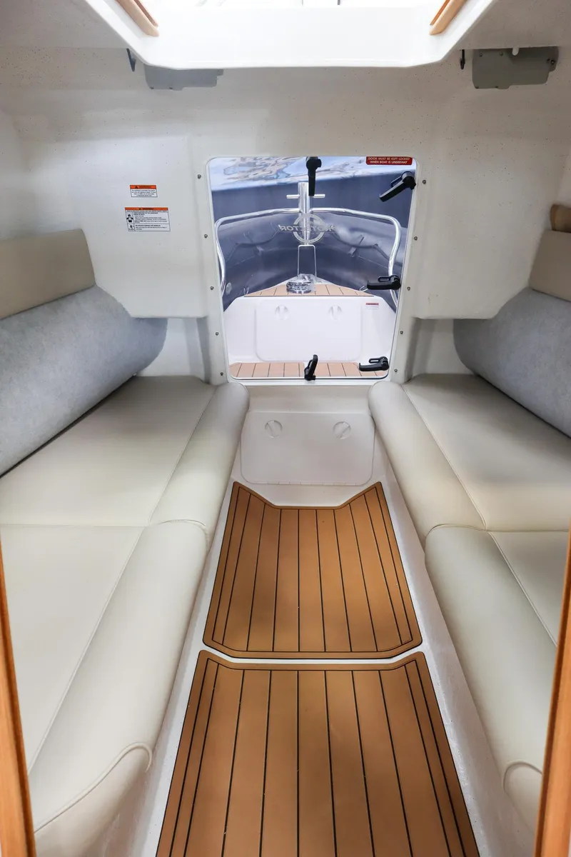 Slide: The Image of Interior of 2025 Protector 310 Targa boat with cushioned seating and wooden flooring. - 14