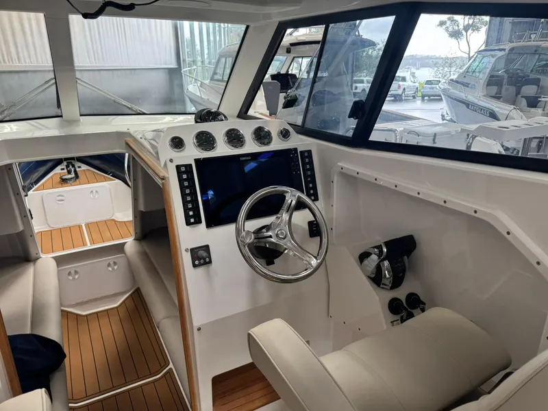 Slide: The Image of Interior of 2025 Protector 310 Targa boat with modern dashboard and steering wheel. - 6