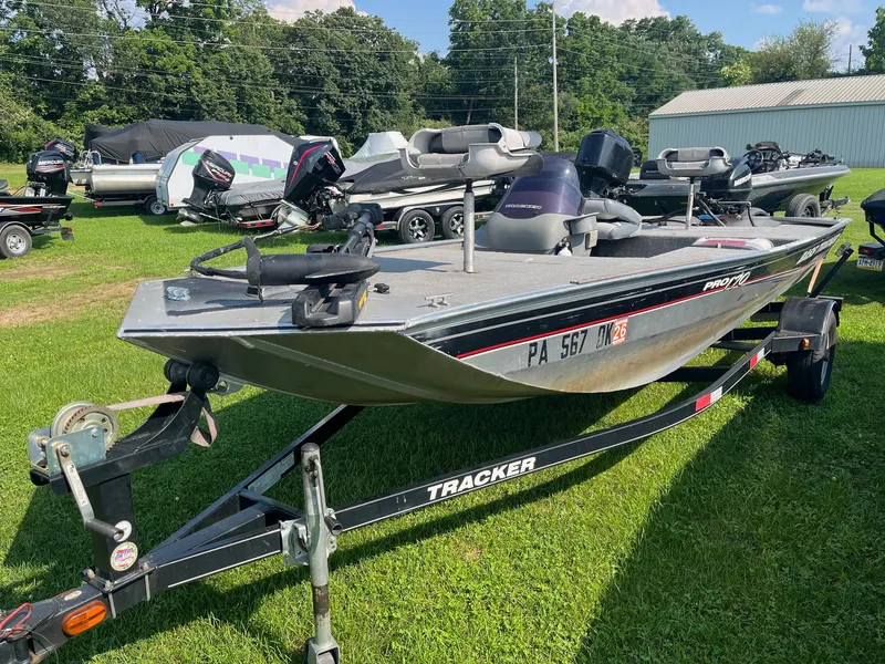 Slide: The Image of 2013 Tracker Pro 170 boat on trailer, parked on grass with other boats nearby. - 4