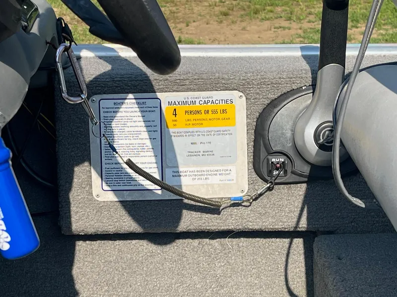 Slide: The Image of 2013 Tracker Pro 170 boat dashboard with capacity label and ignition key. - 6