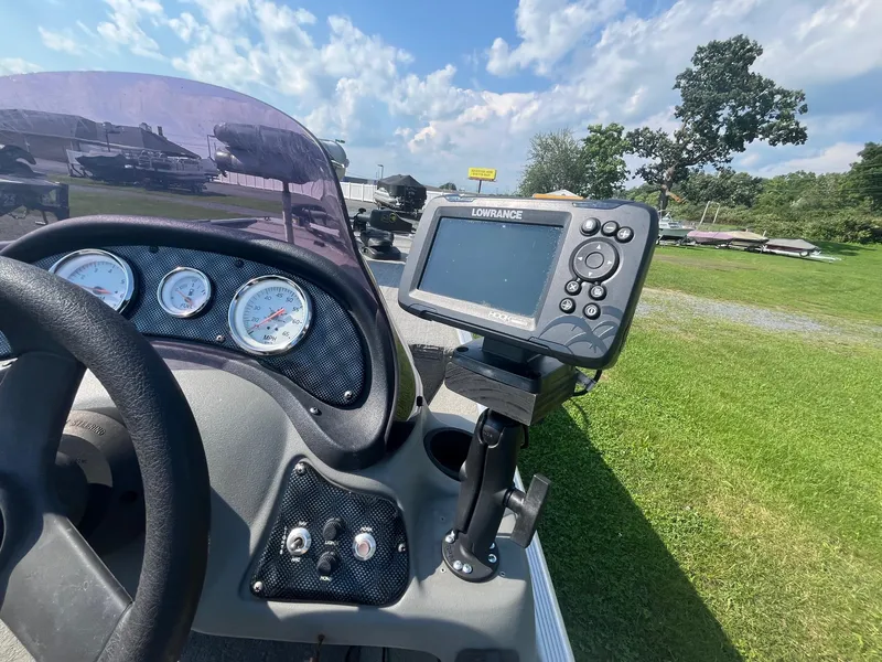 Slide: The Image of 2013 Tracker Pro 170 boat dashboard with Lowrance fishfinder and gauges, outdoors on grass. - 7