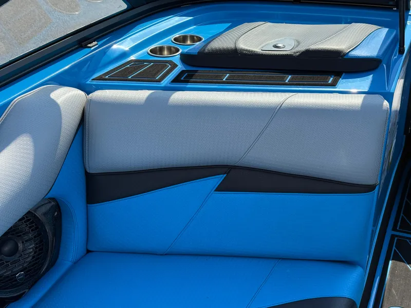 Slide: The Image of 2022 Centurion Fi23 boat interior with blue and gray seating, cup holders, and speaker. - 10