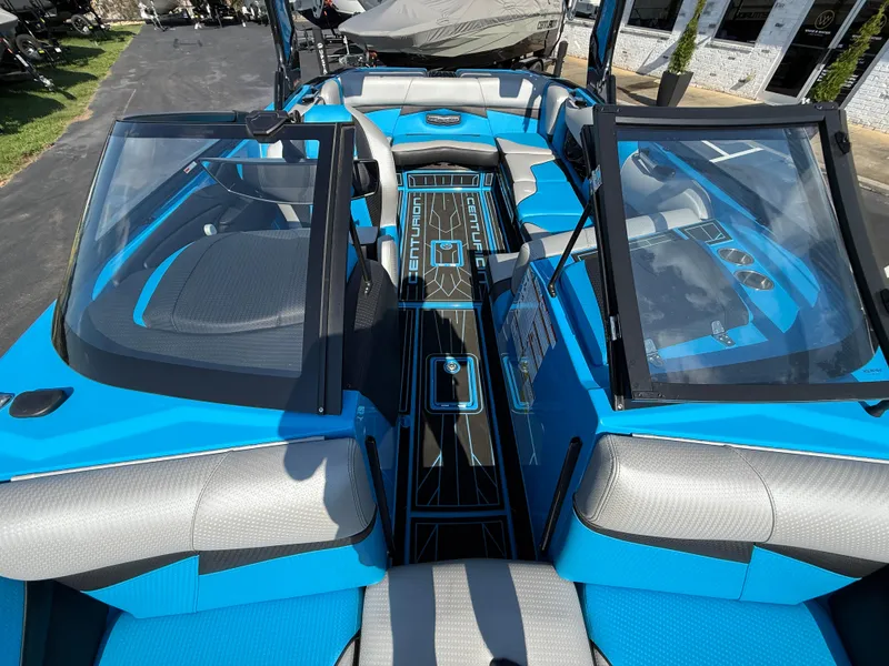 Slide: The Image of 2022 Centurion Fi23 boat interior with blue and gray seating, open windshield, and sleek design. - 11