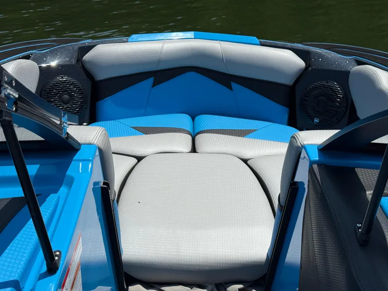 Slide: The Image of 2022 Centurion Fi23 boat interior with blue and gray seating, featuring built-in speakers. - 13