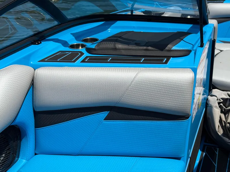 Slide: The Image of 2022 Centurion Fi23 boat interior with blue and gray seating, cup holders, and sleek design. - 16