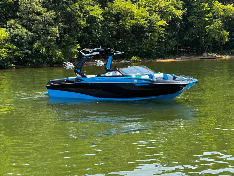 Slide: The Image of 2022 Centurion Fi23 boat in blue and black on a calm lake. - 3