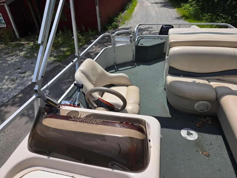Slide: The Image of 2006 Sun Tracker FISHIN' BARGE 21 Signature Series boat interior with steering wheel and seating. - 13