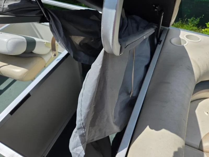 Slide: The Image of 2006 Sun Tracker FISHIN' BARGE 21 interior with open storage compartment and seats. - 16