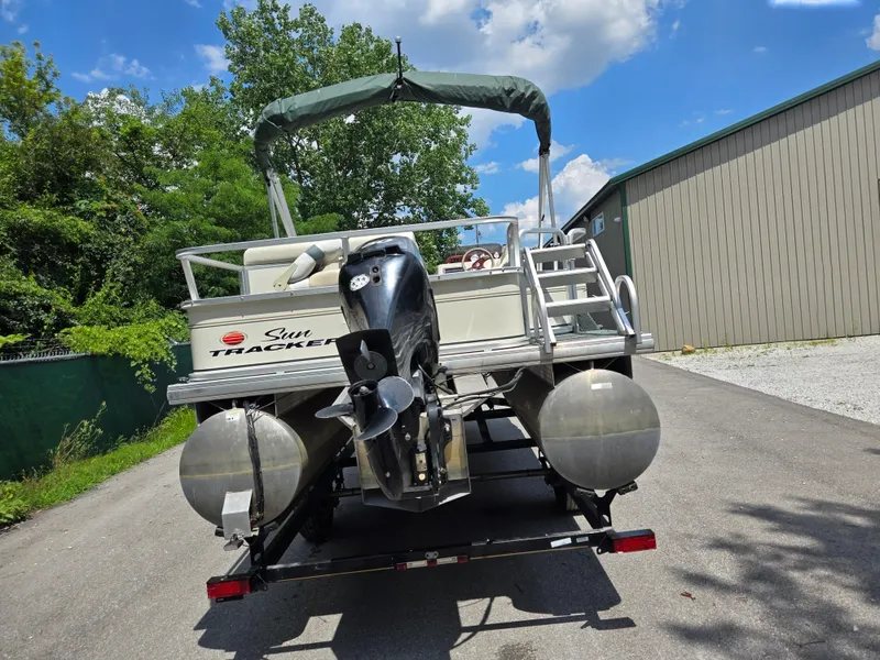 Slide: The Image of 2006 Sun Tracker FISHIN' BARGE 21 Signature Series pontoon boat on trailer, outdoors. - 2