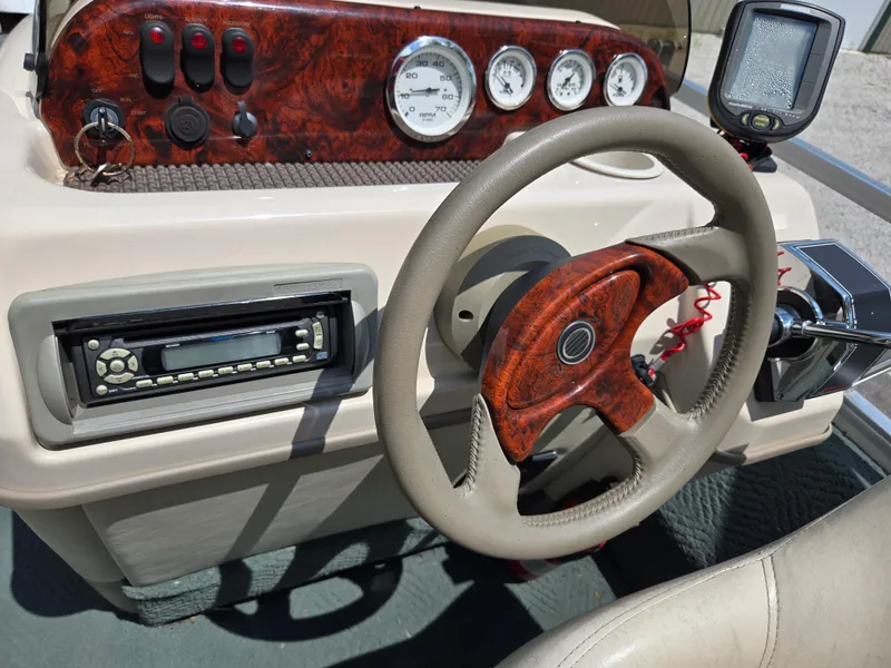 Slide: The Image of Steering console of 2006 Sun Tracker FISHIN' BARGE 21 with wood accents and gauges. - 22