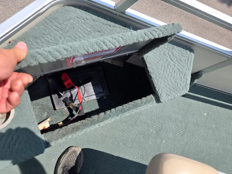 Slide: The Image of 2006 Sun Tracker FISHIN' BARGE 21 battery compartment with green carpet and wiring. - 25