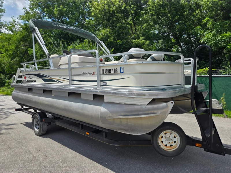 Slide: The Image of 2006 Sun Tracker FISHIN' BARGE 21 Signature Series pontoon boat on trailer, parked outdoors. - 8