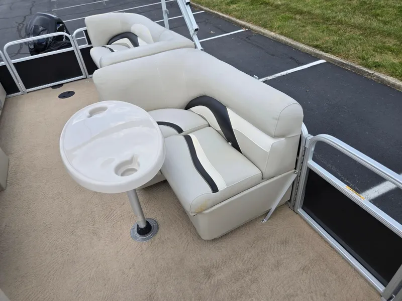 Slide: The Image of 2012 Sweetwater 2486 boat interior with beige seating and round table. - 13
