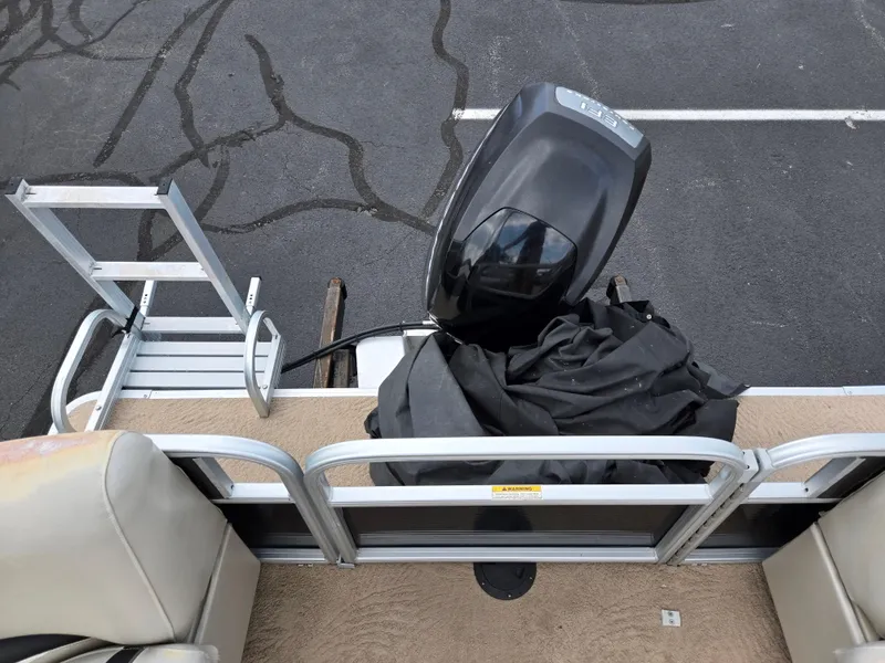 Slide: The Image of 2012 Sweetwater 2486 boat with outboard motor and ladder on a parking lot. - 17