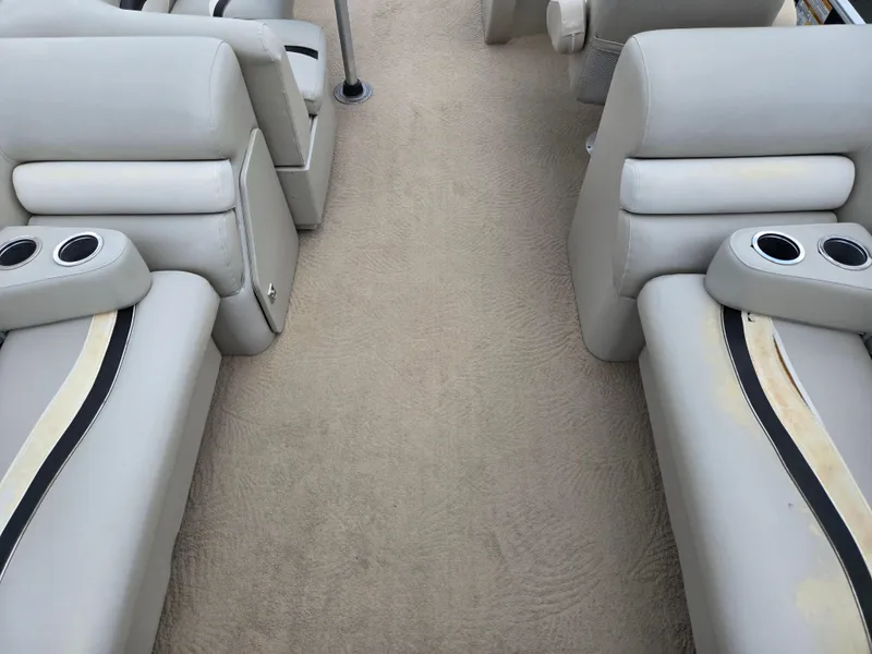 Slide: The Image of Interior of a 2012 Sweetwater 2486 boat with beige seating and cup holders. - 18