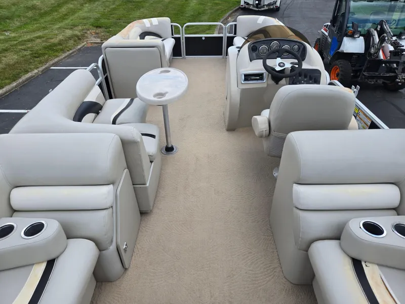 Slide: The Image of Interior of a 2012 Sweetwater 2486 pontoon boat with beige seating and steering console. - 19