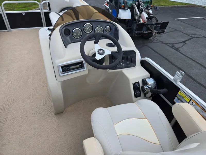 Slide: The Image of 2012 Sweetwater 2486 boat helm with steering wheel and control panel. - 20