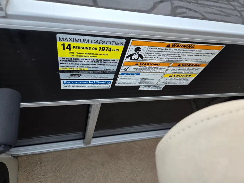 Slide: The Image of Warning labels on a 2012 Sweetwater 2486 boat, detailing capacity and safety information. - 21