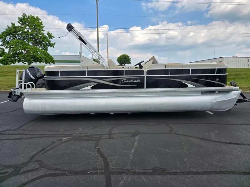 Slide: The Image of 2012 Sweetwater 2486 pontoon boat with Mercury engine, parked on asphalt under cloudy sky. - 4
