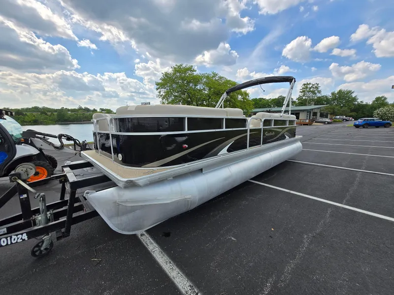 Slide: The Image of 2012 Sweetwater 2486 pontoon boat on trailer in parking lot under blue sky. - 8