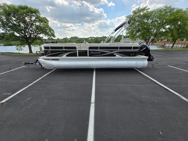 Slide: The Image of 2012 Sweetwater 2486 pontoon boat parked on asphalt near a lake, surrounded by trees. - 9