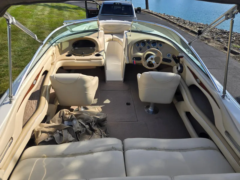 Slide: The Image of Interior of a 1999 Sea Ray 210 BR boat with beige seating and dashboard. - 10
