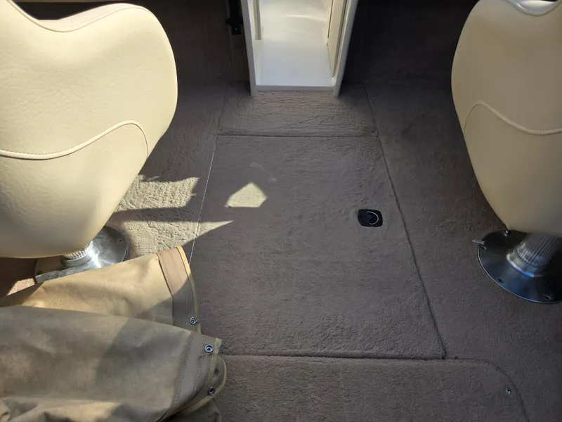 Slide: The Image of Interior of a 1999 Sea Ray 210 BR boat with beige seats and carpeted floor. - 11