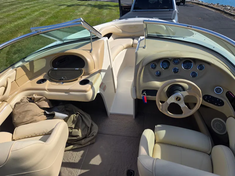 Slide: The Image of Interior of a 1999 Sea Ray 210 BR boat with beige seating and dashboard. - 13