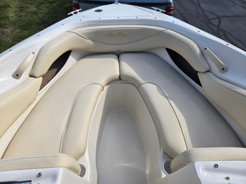 Slide: The Image of 1999 Sea Ray 210 BR boat interior with beige seating and sleek design. - 19