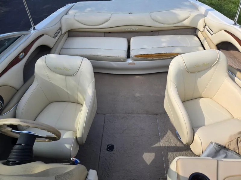 Slide: The Image of 1999 Sea Ray 210 BR boat interior with beige seating and steering wheel. - 23