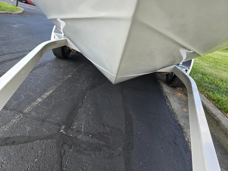 Slide: The Image of 1999 Sea Ray 210 BR boat on trailer, parked on asphalt near grass. - 7