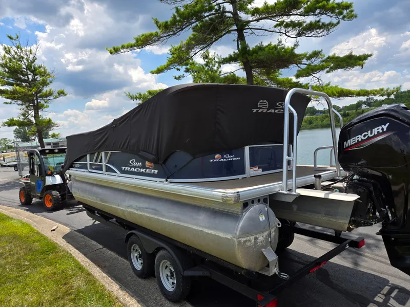 Slide: The Image of 2022 Sun Tracker Party Barge 20 DLX pontoon boat on trailer by a lake. - 10