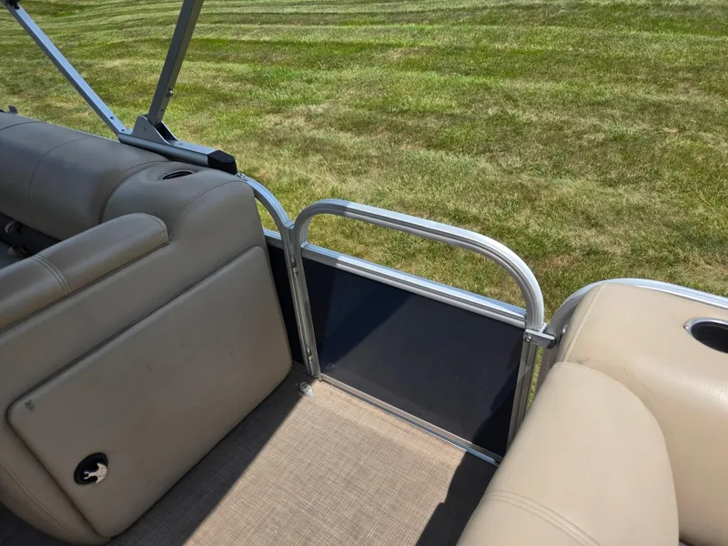 Slide: The Image of 2022 Sun Tracker Party Barge 20 DLX interior with beige seating and open gate. - 13