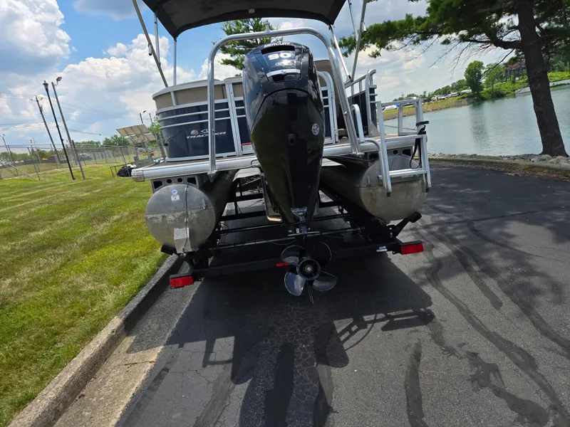 Slide: The Image of 2022 Sun Tracker Party Barge 20 DLX pontoon boat on trailer by a lake. - 2