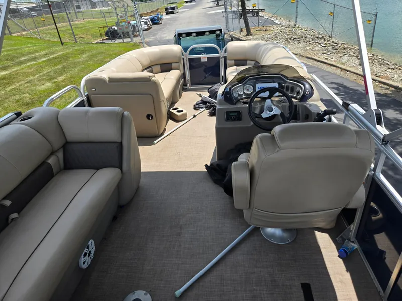 Slide: The Image of 2022 Sun Tracker Party Barge 20 DLX interior with beige seating and steering console. - 20
