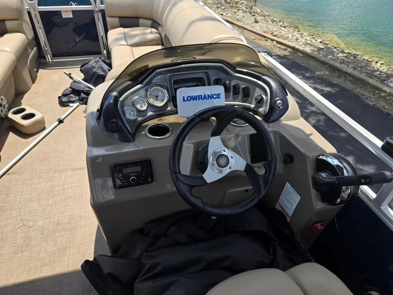 Slide: The Image of 2022 Sun Tracker Party Barge 20 DLX dashboard with steering wheel and controls. - 21