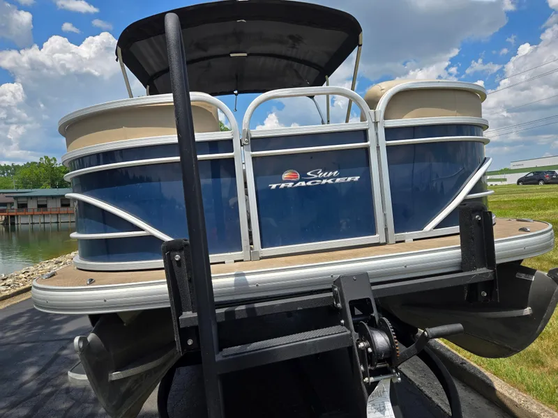 Slide: The Image of 2022 Sun Tracker Party Barge 20 DLX pontoon boat on trailer, blue and beige design. - 6