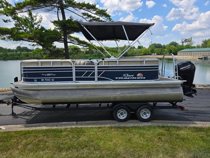 Slide: The Image of 2022 Sun Tracker Party Barge 20 DLX pontoon boat on trailer by a lake. - 9
