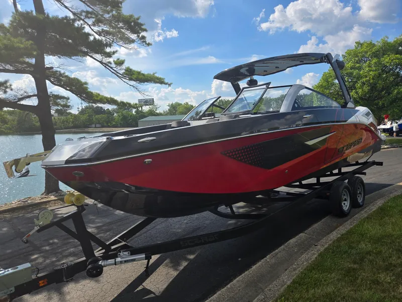 Slide: The Image of 2021 Scarab 285 ID boat on trailer by a lake, under a clear blue sky. - 8