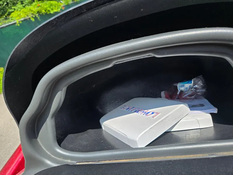 Slide: The Image of Open storage compartment in a 2017 Skeeter TZX 190 boat with items inside. - 12