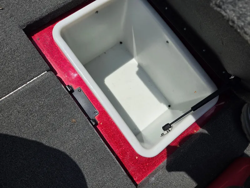 Slide: The Image of Open storage compartment in 2017 Skeeter TZX 190 boat, featuring red trim and hydraulic lift. - 20