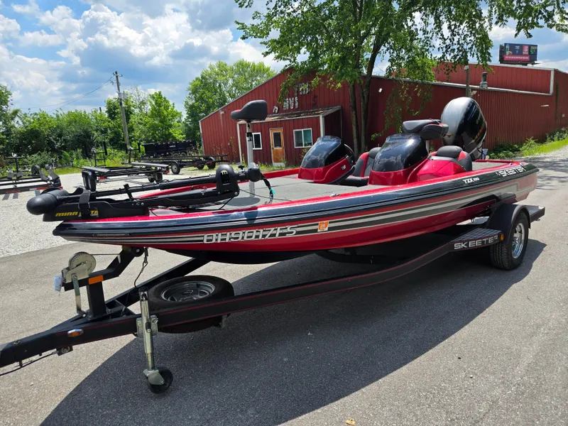 Slide: The Image of 2017 Skeeter TZX 190 boat on trailer, parked outdoors near a red building. - 5