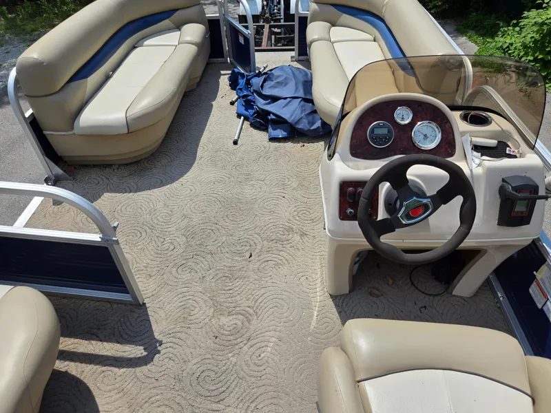Slide: The Image of 2013 Sun Tracker Party Barge 18 DLX interior with beige seating and steering console. - 15