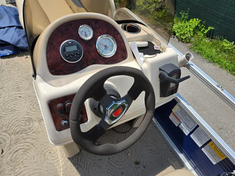 Slide: The Image of 2013 Sun Tracker Party Barge 18 DLX steering console with gauges and controls. - 17